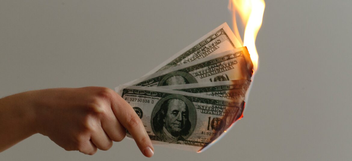 Dinheiro queimando para representar o dinheiro da reserva de emergência