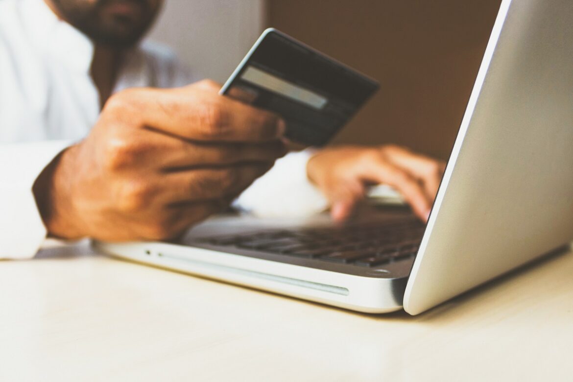 Homem usando o cartão de crédito para fazer compras online