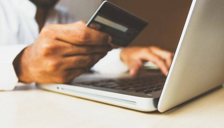 Homem usando o cartão de crédito para fazer compras online